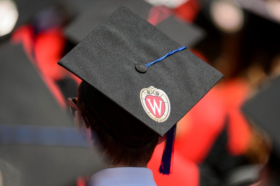 Back of person's head wearing graduation cap adorned with W crest.